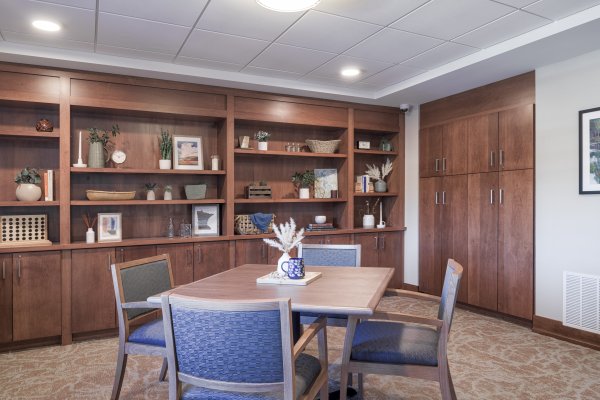 resident community room and library with shelves and table and chairs