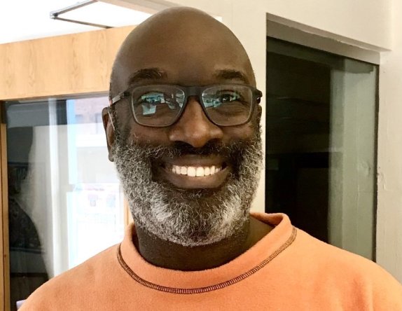 a man with glasses smiling