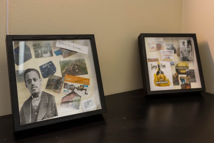 two shadowboxes on a table leaning against the wall highlighting two different inventors