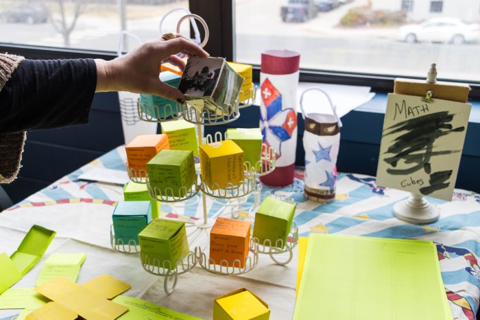a rack holding cubes made from paper with writing on the sides of each cube