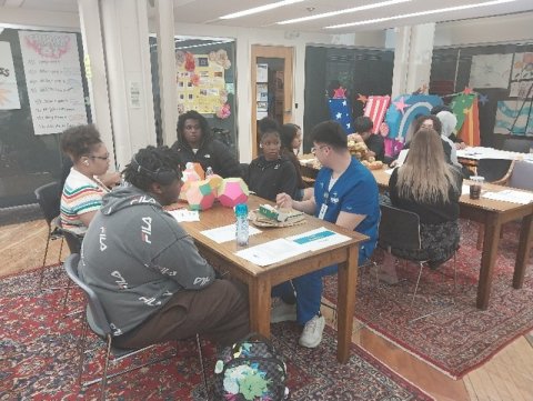 a group of students sitting around a table discussing a table