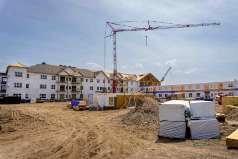 Construction site of an apartment building being built with a large crane