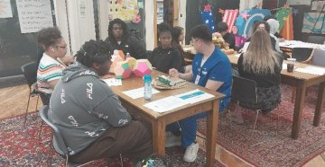 a group of students sitting around a table discussing a table
