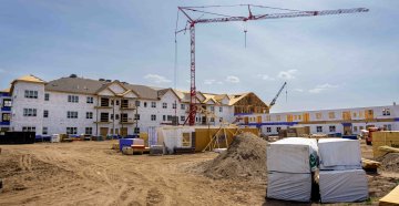 Construction site of an apartment building being built with a large crane