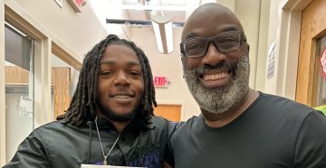 A student standing with a teacher smiling 