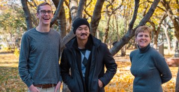 Hans Dosland, Fong Lee and Laura Thelander standing together outside in front of a tree