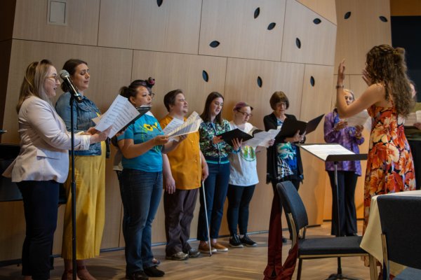 Group of women standing in a line singing