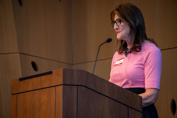 A women standing on a stage at a podium giving a speech