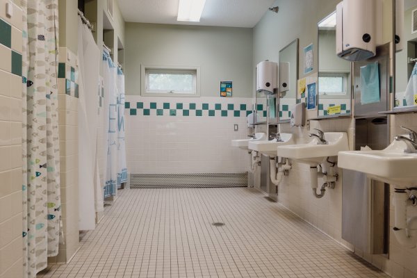 Bathroom with sinks on right side and showers on left side