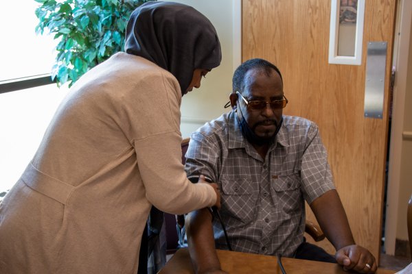 A Community Health Worker checking the blood pressure of her client