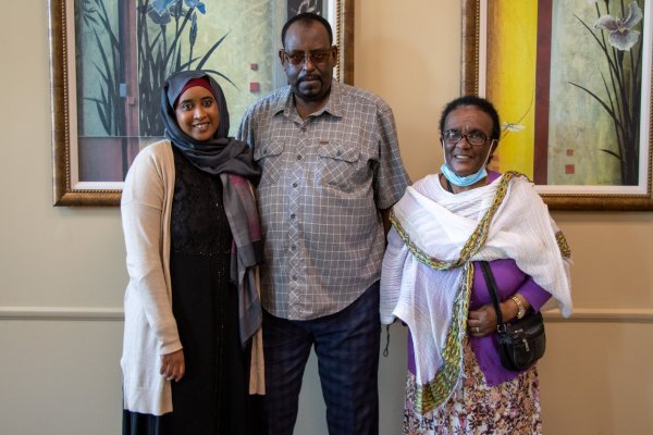 A Community Health Worker stands with two of her regular clients