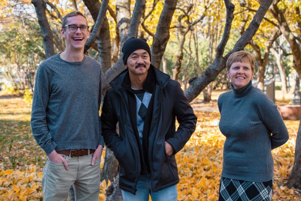 Hans Dosland, Fong Lee and Laura Thelander standing together outside in front of a tree